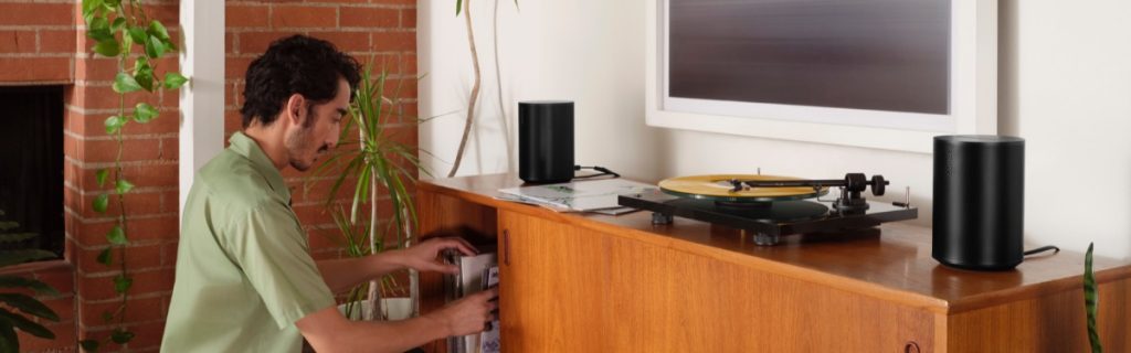 Man listening to Sonos Era 100 stereo pair with turntable